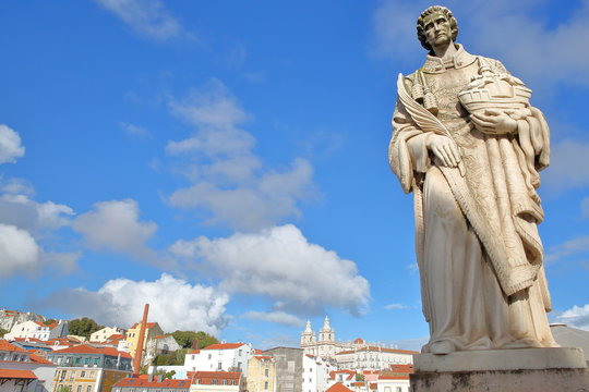 Close-up on Sao Vicente Statue at Santa Luzia viewpoint (miradouro) with Sao Vicente de Fora Church in the background, Lisbon, Portugal