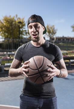 Stylish man holding basketball ball