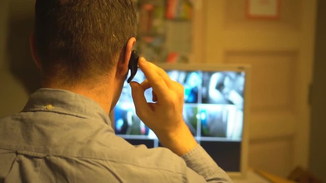 Security guard monitoring video in security room. From the back.
