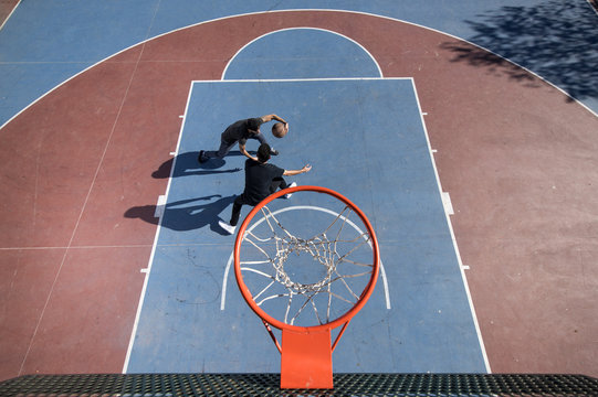 Friends playing street ball near basketball hoop