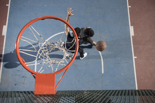 Friends playing street ball near basketball hoop