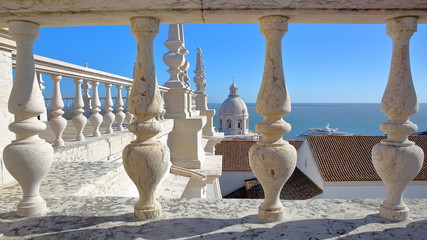 The rooftop of Sao Vicente de Fora Church (with ornately decorated sections in the Baroque style): View towards The National Pantheon (Santa Engracia Church) and The Tagus river, Lisbon, Portugal