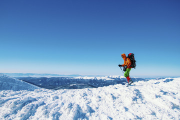 Winter hike in the mountains with a backpack and tent.