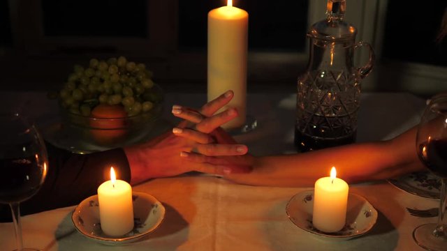 Close-up Of The Hands Of Men Holding Women's Hands During A Romantic Dinner