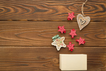 A beige box, straws with Christmas pattern and homemade gingerbreads on a rustic wooden background. Christmas background. Copy space. Top view