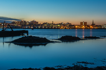 Night photo view of Portland Maine, USA. The smooth water, the city's buildings on the other shore...