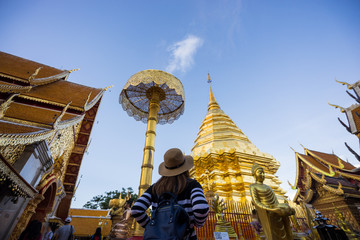 Young woman traveler traveling to Wat Phra That Doi Suthep temple. This temple contains supreme examples of Lanna art in the old city center of Chiang Mai,Thailand.