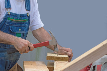 With hammer in hand, the unidentified handyman begins a building project.