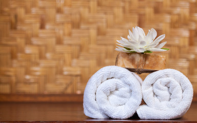Fototapeta na wymiar Towel and soap on wooden table, spa and wellness concept
