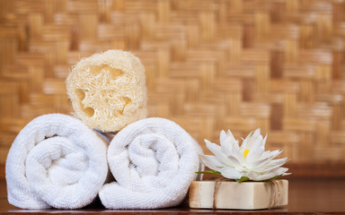 Obraz na płótnie Canvas Towel, soap and luffa scrub on wooden table, spa and wellness concept