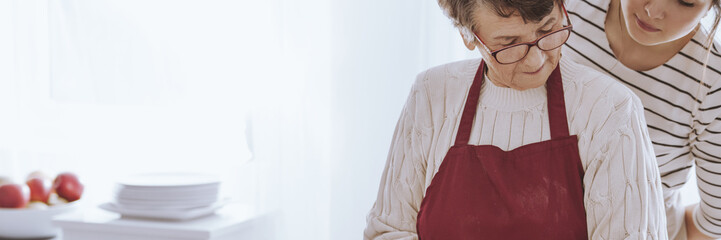 Grandmother preparing food with granddaughter
