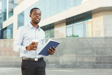 Portrait of a confident young black businessman with notepad
