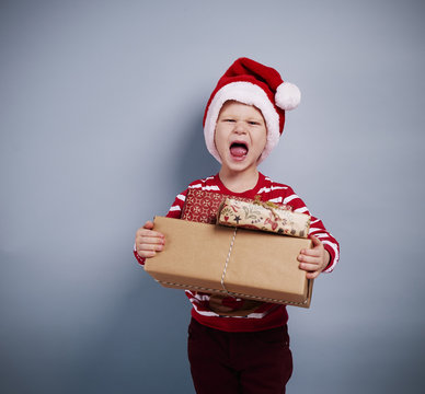 Portrait of boy with christmas gifts .