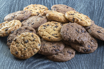 Cookies chocolat et caramel en tas sur fond noir