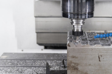 The CNC milling machine cutting cutting the raw material with the small ball-end mill tool .Hi-precision CNC machining concept.