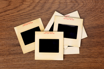 Vintage 35-mm mounted film slides on wooden background