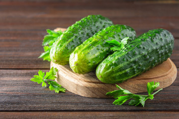 Fresh raw green cucumbers on a wooden table.