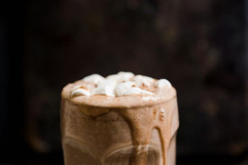 Hot chocolate with marshmallow on the wooden background. Shallow depth of field. Toned image.