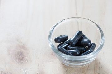 Activated charcoal pills for Diarrhea treatment on wooden background