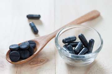 Activated charcoal pills for Diarrhea treatment on wooden background