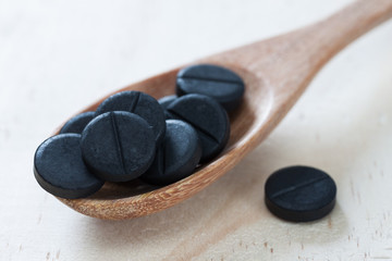 Activated charcoal pills for Diarrhea treatment on wooden background