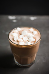 Hot chocolate with marshmallow on the wooden background. Shallow depth of field. Toned image.