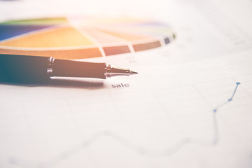 Sales report analysis with pen.  Business Concept, select focus