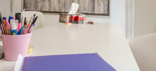 Ofifce. Container with pens and a folder on the table 