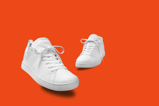 Pair of White sneaker isolated on orange background with clipping path
