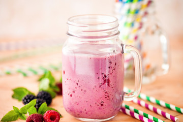 Delicious blackberry raspberry smoothie with mint and fresh berries in glasses. Selective focus.