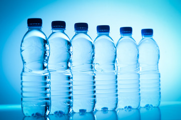Plastic bottles of water isolated on blue