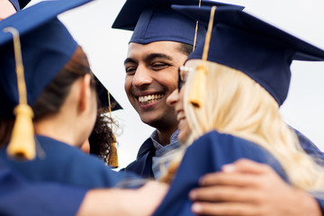 happy students or bachelors in mortar boards