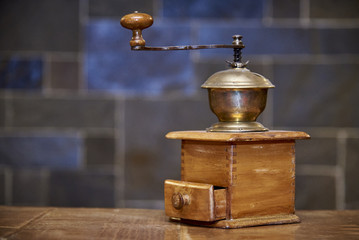 Fototapeta na wymiar Vintage wooden coffee grinder stands on a table on a blurred background