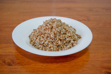 Buckwheat porridge in white plate. Healthy food..