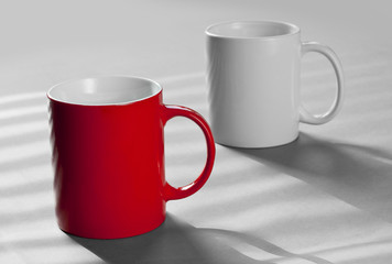 Red and white mugs standing on a grey table