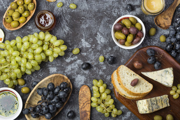 snacks of blue cheese, olives, bread and grapes