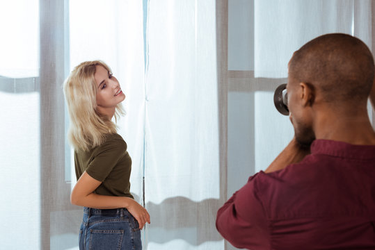 african american photographer taking photo of attractive model in studio