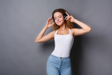 Woman listen to music in earphones, studio shot