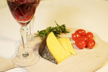 pieces yellow cheese and small red tomatoes with wine