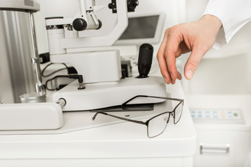 Ophthalmology, eye check and correction vision. Male hand and glasses at the latest digital optical store