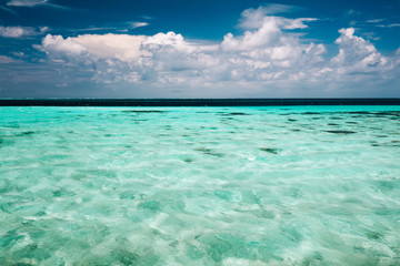 Clear ocean water and a cloudy blue sky