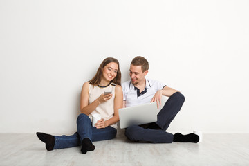 Fototapeta na wymiar Young couple web surfing on laptop