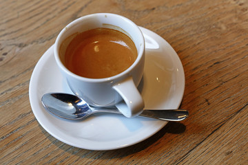 Close up white cup of espresso coffee on table