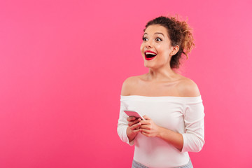 Portrait of a cheerful happy girl holding mobile phone
