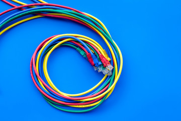 Network colored cables for computer on blue background top view copyspace