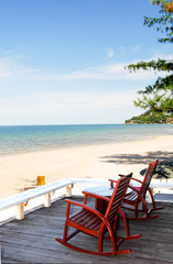 table with chairs. On the sandy beach