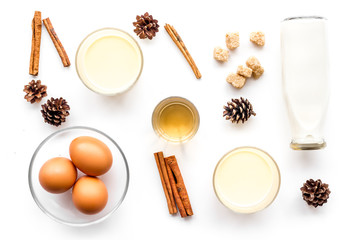 Ingredients for eggnog. Eggs, milk, cinnamon, whiskey on white background top view