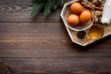 Make eggnog classic recipe. Eggs, milk, cinnamon, whiskey on dark wooden background top view copyspace