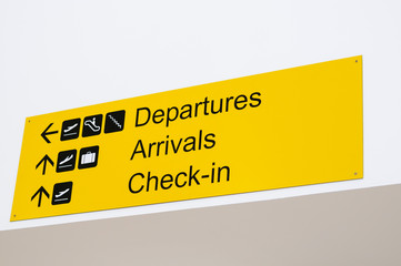 Sign in an airport with directions to departures, arrivals and check-in