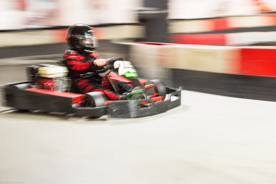 Cart (kart) blurred by high speed, a boy having fun - driving fast, racing, speeding. 